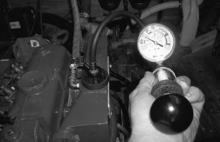 A basic pressure tester with adapters hooked up to Rudy and Jill’s engine.