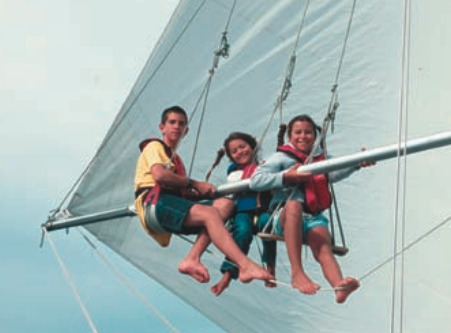 When they got older, the Martin children discovered the wonders of their sailboat above the deck level. Three young Martins — Chris, Teiga, Holly — observe life from a higher perch, above.