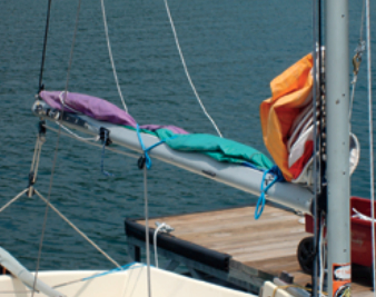 Mainsail frapped down using bungees. Lazy-jacks help.