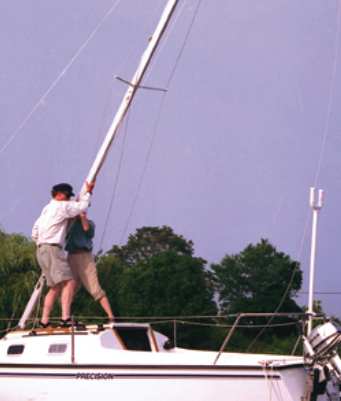 Two men putting up a mast on a boat