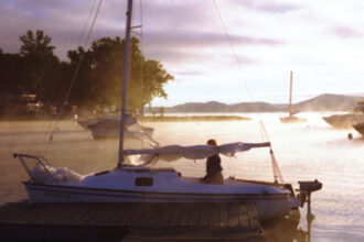 A picture of a boat in the sunrise
