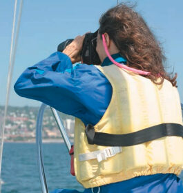 Picture of a woman using binoculars on a boat