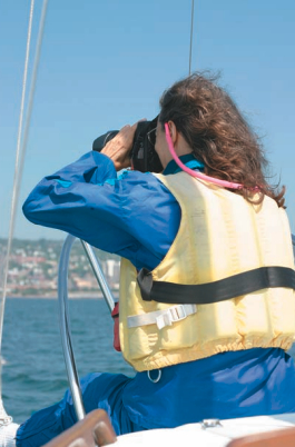 Picture of a woman using binoculars on a boat