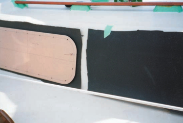 The new portlights are positioned over the gasket material and ready to be screwed down.