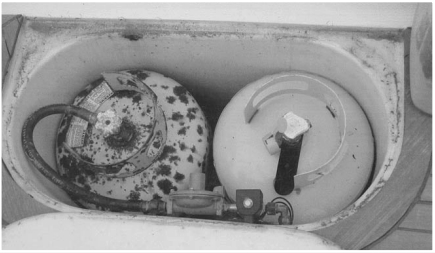A real-world propane locker of a 46-foot yacht that has just returned from a round-the-world trip. One tank is pitted and needs wire-brushing and painting. There is no pressure gauge fitted. Both cylinders are 20-pound tanks.