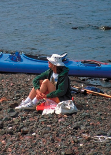 Picture of a woman sitting on a rock beach