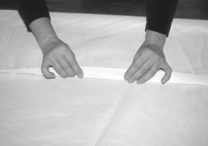 Once the panel was stuck in place, Gregg folded the 1 1⁄2-inch edge strip over and against the other side of the sail to protect the edge of the sail.