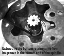 Extracting the bottom retainer ring from its groove in the bottom end of the spindle.