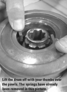 Lift the drum off with your thumbs over the pawls. The springs have already been removed in this picture.