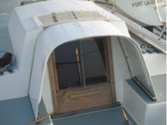 I solved the leaky sliding hatch problem aboard Direction by removing it completely and building a fixed hard dodger. Note the swing doors and a hinging “sill board,” all gasketed. It was a difficult companionway to maneuver, but it was very dry.