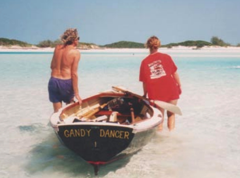 Walking the dory through shallows on the way to diving for crayfish, near Norman’s Cay, Bahamas.