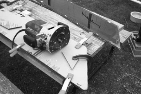 A makeshift boatyard worktable is the collection point for clamps and cutting tools, at right.