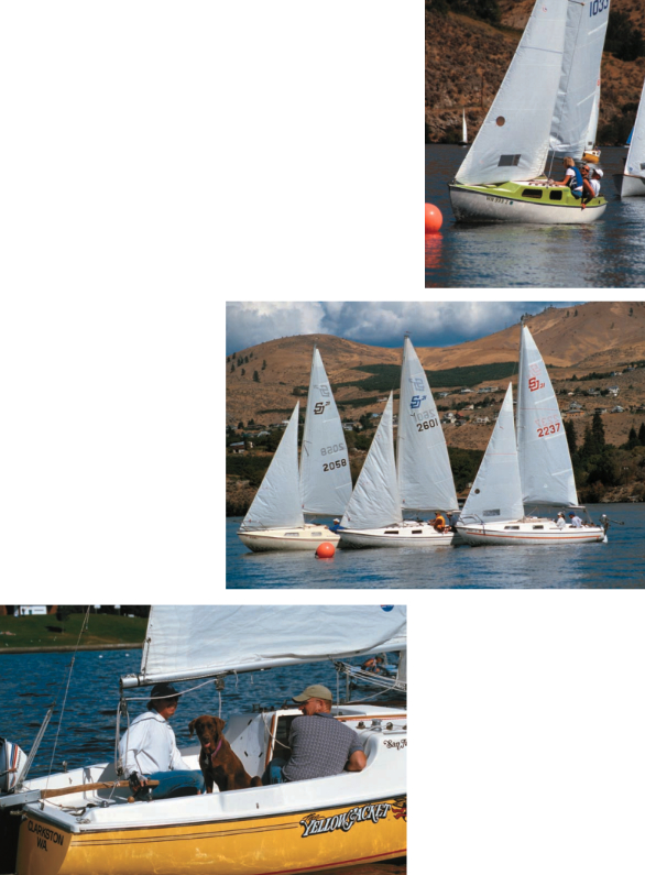 Tight racing on a nearly windless day. Author Ed Lawrence notes that the race was punctuated by laughter. Another clue that this race is just for fun is the four-legged crewmember on Yellow Jacket. A San Juan 21 Mark I is at top. Compare the foredeck with the Mark II versions in center photo. Yellow Jacket is a Mark II version.