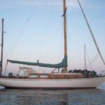 Christmas, a classic 38-foot 6-inch John Alden design built during the era of the CCA Rule, shows her overhanging stern and spoon bow to advantage in the fading light of a Maine sunset. One of the early fiberglass boats, she was one of approximately 50 Alden Challengers built in the 1960s.