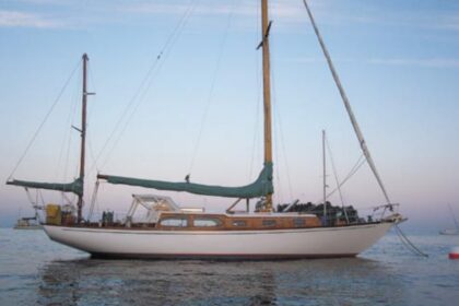 Christmas, a classic 38-foot 6-inch John Alden design built during the era of the CCA Rule, shows her overhanging stern and spoon bow to advantage in the fading light of a Maine sunset. One of the early fiberglass boats, she was one of approximately 50 Alden Challengers built in the 1960s.