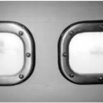 John Karklins’ finished portlights above. He recommends against using polycarbonate. It gets cloudy, as the illustration shows. The teak spacer he added to compensate for the additional thickness of his “armor-plated windows” shows around the edges of the frame.
