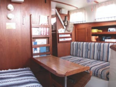 The table in the main saloon folds down (as shown) and a leaf can be raised to starboard. The original upholstery is still in good condition, though Frank often covers the settees with Mexican blankets.
