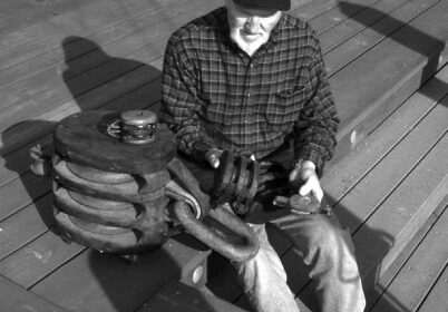 Who’s this gnome? We don’t mean to frighten you, but look what happened to Don Launer before he learned to give his wooden blocks regular maintenance. Actually, he says the large one, which weighs more than 90 pounds, was used to hoist cargo aboard a World War II Liberty Ship.