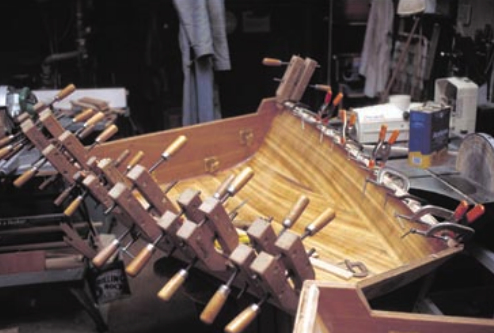 Clamping the gunwales, at right. In boatbuilding, John says, you can never have too many clamps.