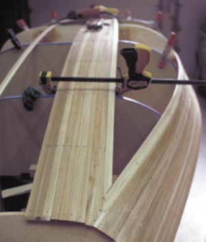 The bow looking aft. John says, “I run the strips off the ends and cut them off later. Then, using a belt sander, I sand them down flush with the bow.”