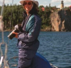 Picture of someone with a camera on a boat