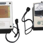 The front of the J. R. Overseas moisture meter, above, shows the moisture scale, while the back side, at left, shows the sensitive sensors.