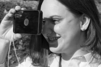 Karla Houdek, that cheerful voice on the phone when you call Good Old Boat, tries out the floating signal mirror the editors bought for their boat.