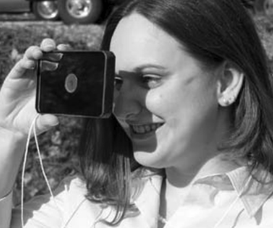 Karla Houdek, that cheerful voice on the phone when you call Good Old Boat, tries out the floating signal mirror the editors bought for their boat.