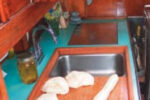 The finished (removable) sinkboard, above, simultaneously improved the functionality of the galley and access to the engine compartment.