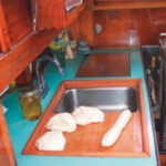The finished (removable) sinkboard, above, simultaneously improved the functionality of the galley and access to the engine compartment.