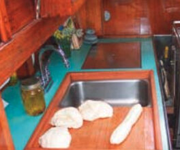 The finished (removable) sinkboard, above, simultaneously improved the functionality of the galley and access to the engine compartment.