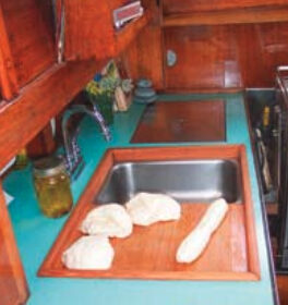 The finished (removable) sinkboard, above, simultaneously improved the functionality of the galley and access to the engine compartment.