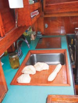 The finished (removable) sinkboard, above, simultaneously improved the functionality of the galley and access to the engine compartment.