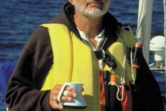 Picture of a man sailing with a cup of coffee in his hand