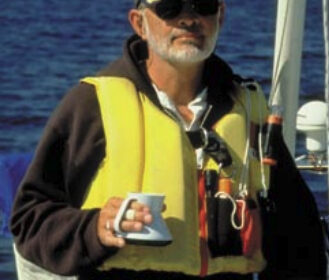 Picture of a man sailing with a cup of coffee in his hand