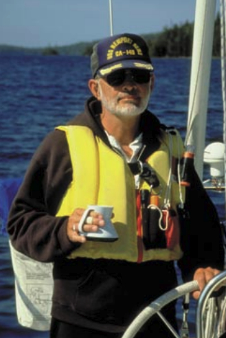 Picture of a man sailing with a cup of coffee in his hand