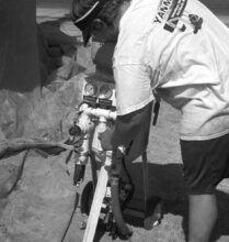 The operator connects his hoses to the soda-blasting equipment.