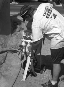 The operator connects his hoses to the soda-blasting equipment.