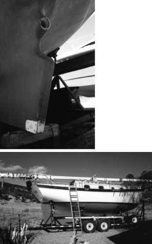The rudder heel attaches with four bronze bolts through the unpainted area, above. Allegra, undergoes repairs, at right.