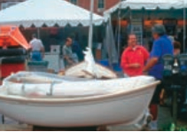 Chris, in the red shirt, talks to potential customers at the Annapolis Sailboat Show (October 2000).