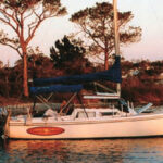 Tequila Sunset, anchored in an island cove on Choctawhatchee Bay, in Florida Panhandle waters. As here, they often set an anchor off the bow and tie the stern to a tree ashore.