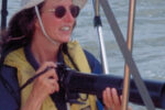 Picture of a woman with a camera on a boat