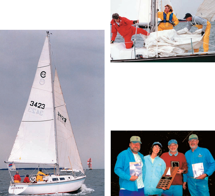 Whoops! Above, the crew of Dan Lawrence’s Triton, Sandpiper, decide mid-race that the #1 isn’t the best sail choice in winds of 20+ knots. At left, Bob and Cindi Gibson’s Cal 2-30, Checkmate, is on its way to cleaning up the Fin-Keel Handicap Class. Below, Regatta co-founders Charlie Husar (left) and Don Frye (right) celebrate with Good Old Boat editors Karen Larson and Jerry Powlas. Karen (the one without a beard) holds the Good Old Boat Perpetual Trophy.