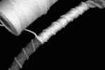 Parceling is the nautical art of wrapping a line with a long strip of heavy cloth, such as canvas or denim, as shown at the left end of this line. The parceling cushions and protects the line and makes a smoother surface for applying the serving twine.