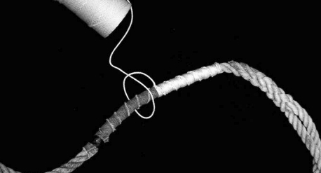 Nylon makes the best serving twine. Wrapping the parceling cloth with the twine will do, but Ken prefers putting half hitches in at each wrap to create a spiral effect and to hold the parceling wrap more securely.