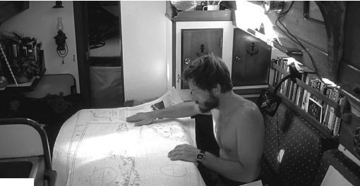 Belowdecks in the finished Nomad, Mark studies a chart of possible cruising grounds.